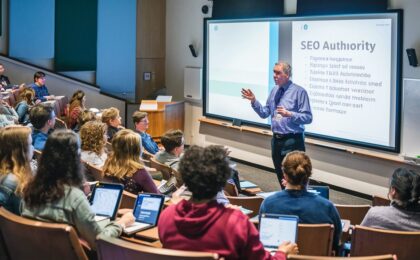 The AI generated image shows a professor giving a lecture in an auditorium on the topic of SEO Authority. We know this because the phrase SEO Authority appears on the display. The image was created for a blog post whose title is "What is a good SEO Authority score?".